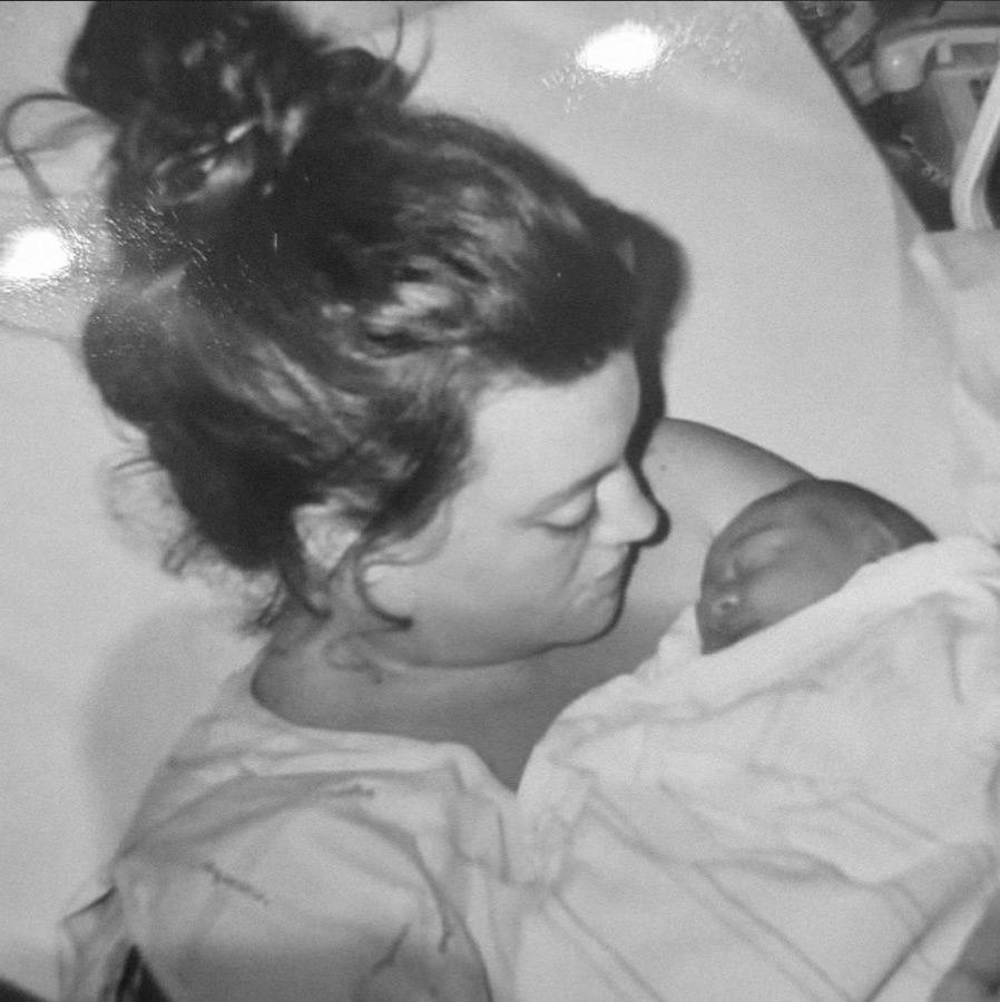 Cameron resting cheek to cheek with her newborn