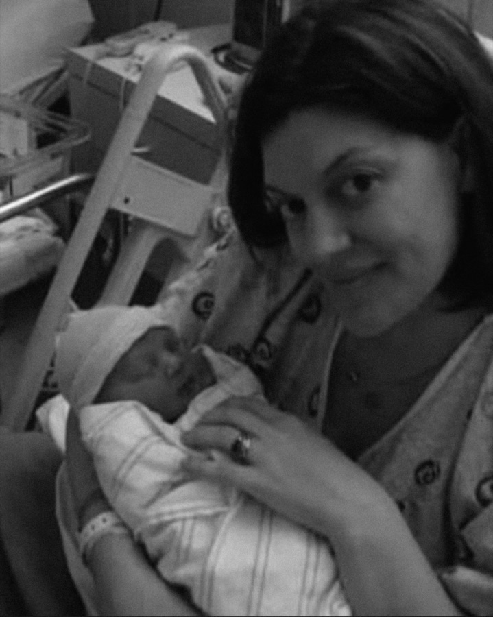 Cameron in hospital with a newborn in her arms